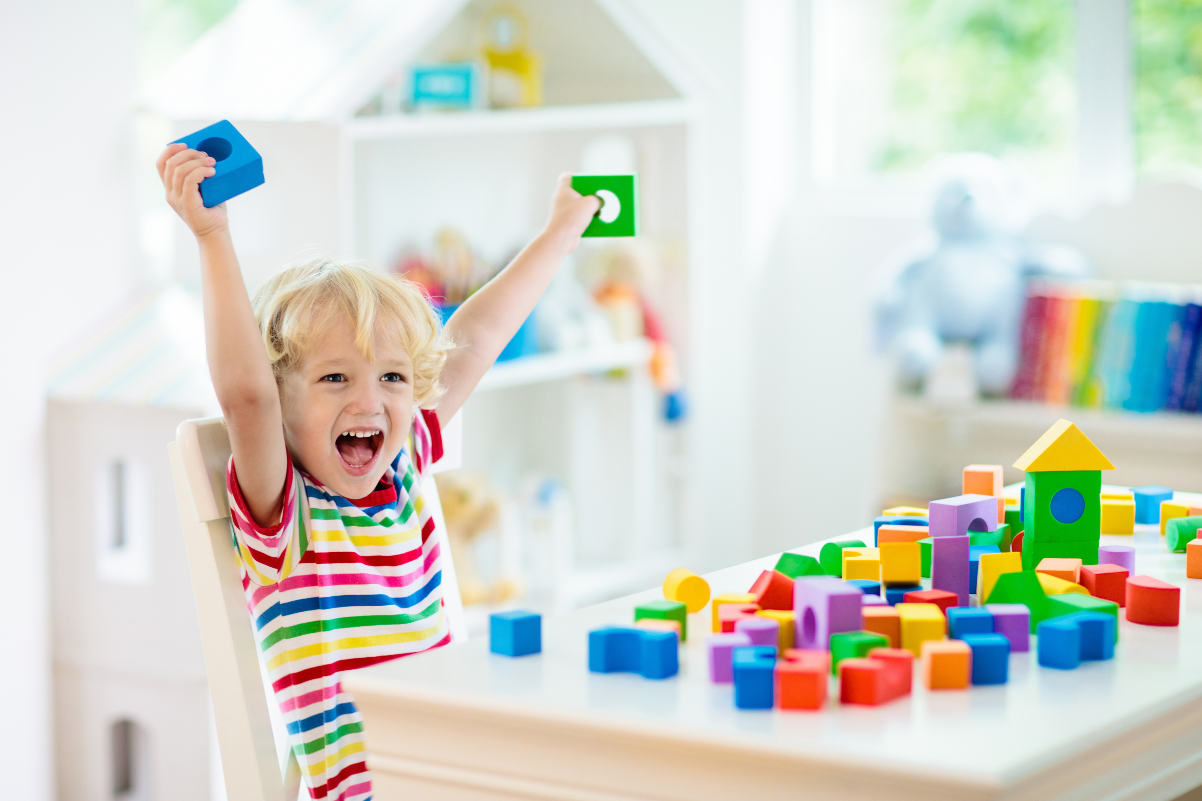 Kids toys. Child building tower of toy blocks.